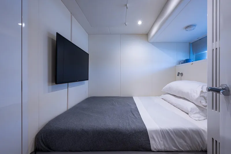 Splash Yacht Photos Pics Luxurious cabin interior of 2022 Princess X95 yacht with modern bed and wall-mounted TV.