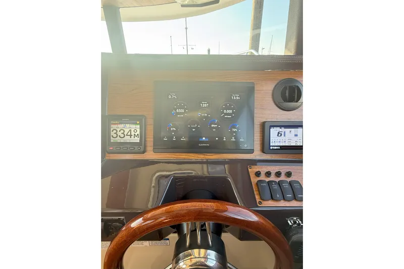 Anima Gemella Yacht Photos Pics 2023 Ranger Tugs R-27 dashboard with Garmin navigation and wooden steering wheel.