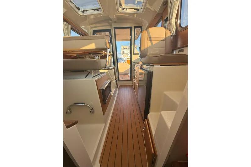 Anima Gemella Yacht Photos Pics 2023 Ranger Tugs R-27 interior with wood flooring and modern seating.