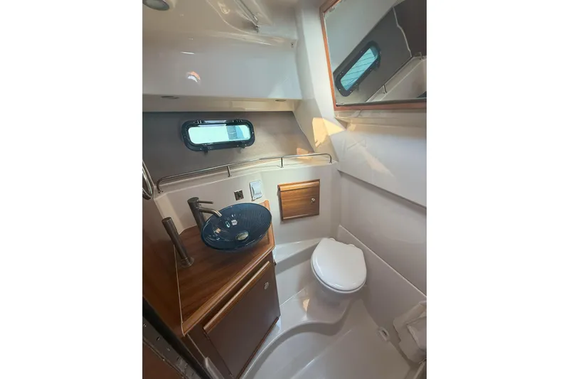 Anima Gemella Yacht Photos Pics 2023 Ranger Tugs R-27 bathroom with modern sink, toilet, and mirror.