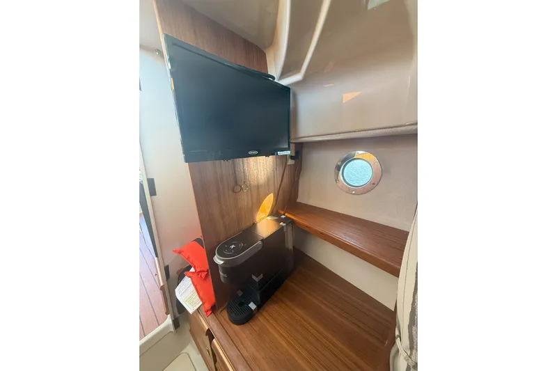 Anima Gemella Yacht Photos Pics 2023 Ranger Tugs R-27 interior with TV, coffee maker, and porthole window.