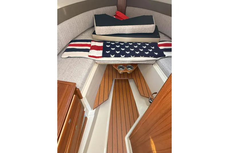 Anima Gemella Yacht Photos Pics 2023 Ranger Tugs R-27 cabin interior with American-themed decor and wooden flooring.