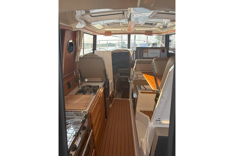 Anima Gemella Yacht Photos Pics Interior of 2023 Ranger Tugs R-27 boat featuring kitchen and seating area.