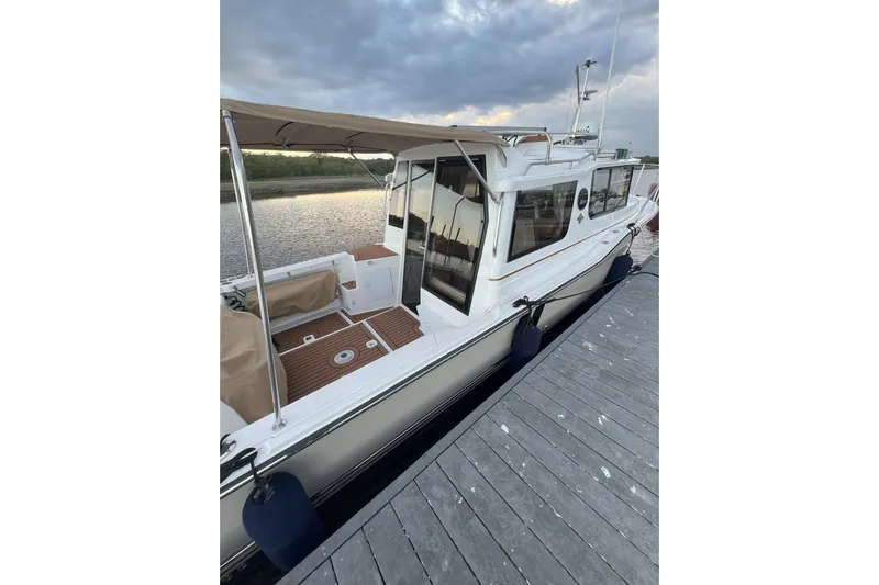 Anima Gemella Yacht Photos Pics 2023 Ranger Tugs R-27 boat docked, featuring a covered deck and sleek design.
