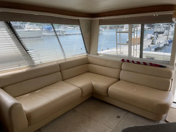  Yacht Photos Pics 1998 Bayliner 4788 Pilot House Motoryacht interior with beige leather seating and marina view.