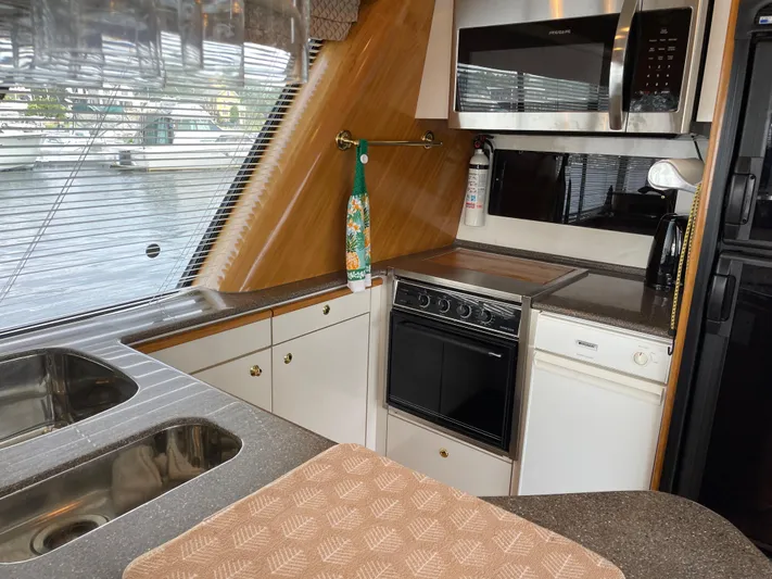  Yacht Photos Pics 1998 Bayliner 4788 Pilot House Motoryacht kitchen with stove, microwave, and sink.