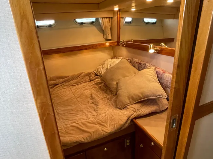  Yacht Photos Pics Cozy bedroom in 1998 Bayliner 4788 Pilot House Motoryacht with plush bedding and wooden accents.