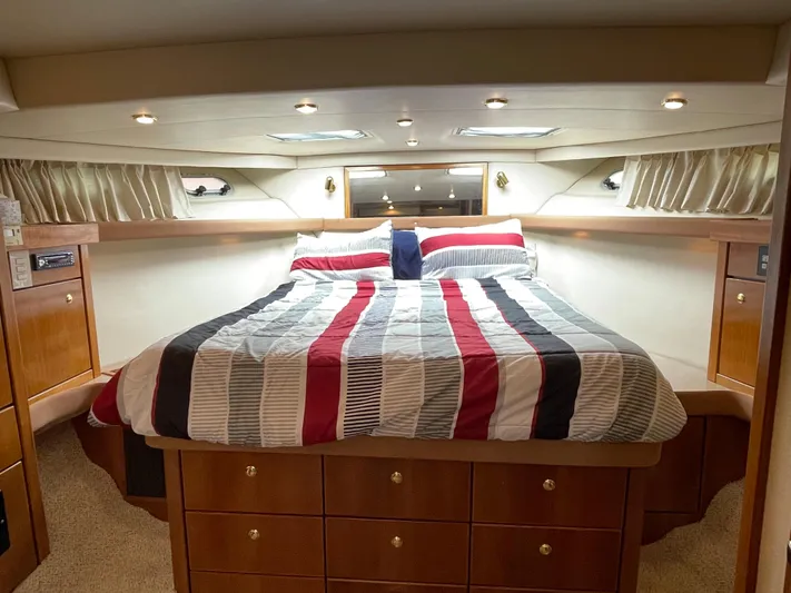 Yacht Photos Pics Luxurious bedroom in 1998 Bayliner 4788 Pilot House Motoryacht with striped bedding.