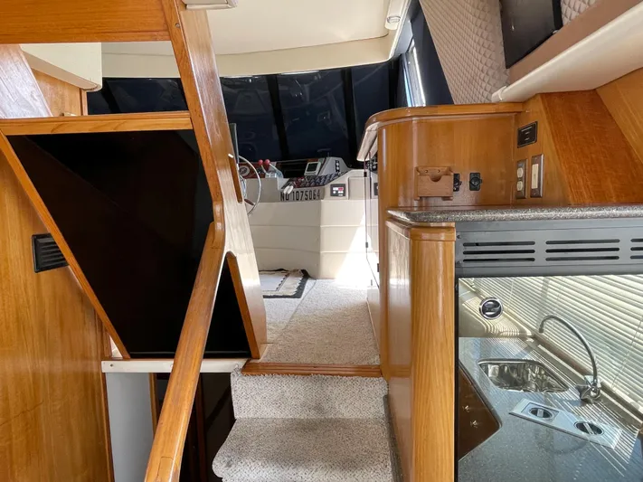  Yacht Photos Pics 1998 Bayliner 4788 Pilot House Motoryacht interior with stairs, helm, and kitchenette.