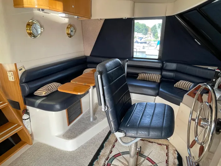  Yacht Photos Pics 1998 Bayliner 4788 Pilot House Motoryacht interior with black leather seating and wooden accents.