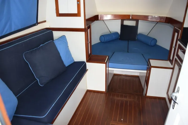 Rampage Yacht Photos Pics 1976 Bertram Flybridge Cruiser interior with blue seating and wooden accents.