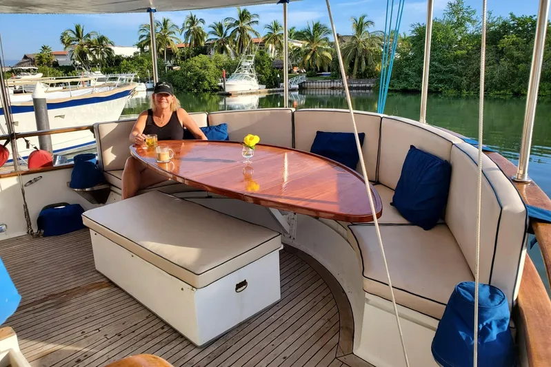  Yacht Photos Pics Woman relaxing on 1982 Cheoy Lee 52 yacht, surrounded by tropical scenery.