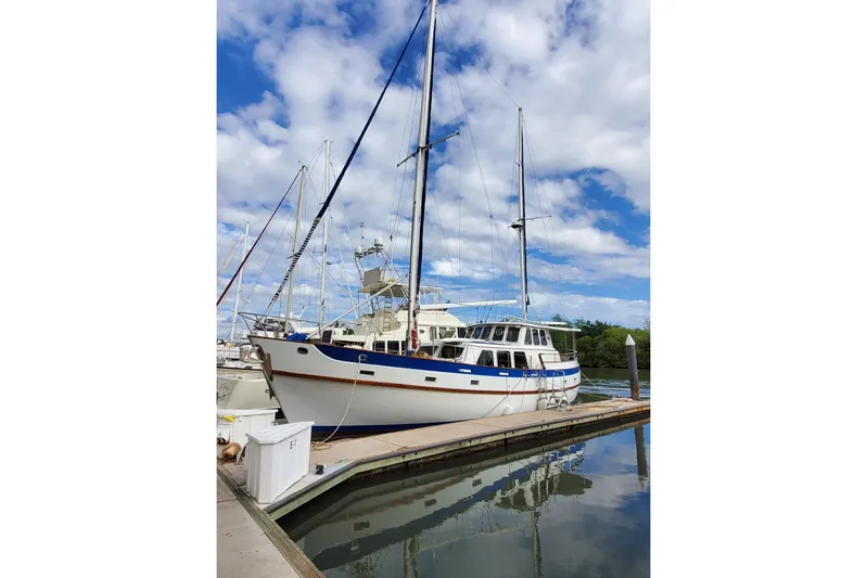  Yacht Photos Pics 1982 Cheoy Lee 52 yacht docked at marina under blue sky.