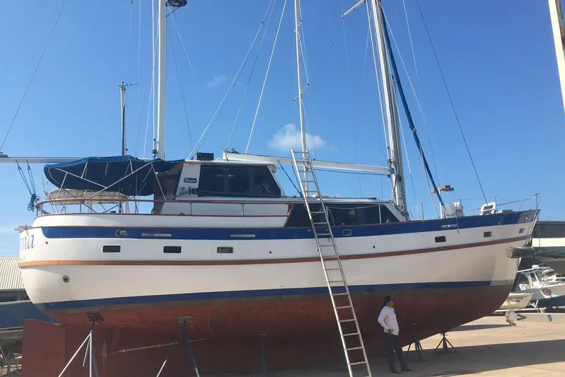  Yacht Photos Pics 1982 Cheoy Lee 52 sailboat on dry dock with ladder and clear blue sky.