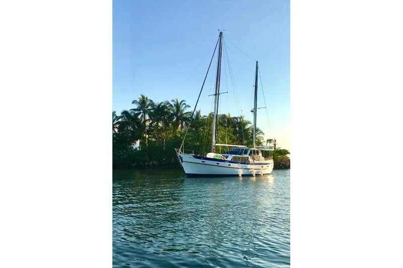  Yacht Photos Pics 1982 Cheoy Lee 52 sailboat anchored near tropical palm trees.