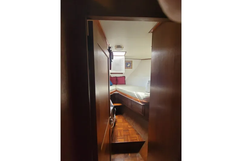  Yacht Photos Pics Interior cabin view of 1982 Cheoy Lee 52 yacht with wooden finish and cozy bedding.