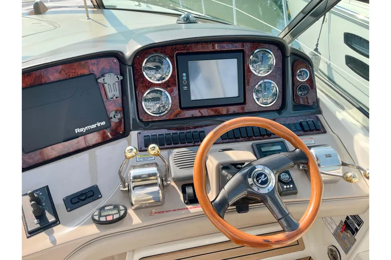  Yacht Photos Pics 2004 Searay 420 Sundancer helm with wood steering wheel and advanced navigation controls.