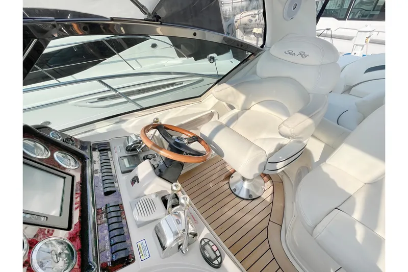  Yacht Photos Pics Cockpit of 2004 Searay 420 Sundancer with luxurious white seating and wooden steering wheel.