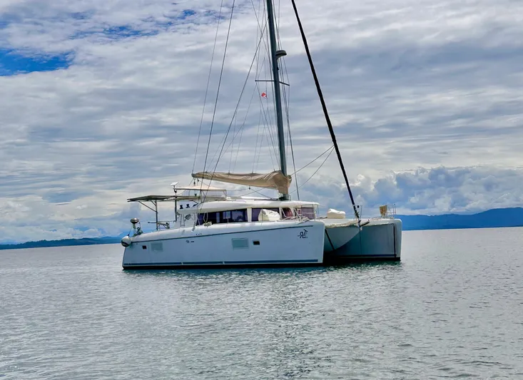 Road Less Travelled Yacht Photos Pics 2013 Lagoon 421 catamaran sailing on calm waters under a cloudy sky.