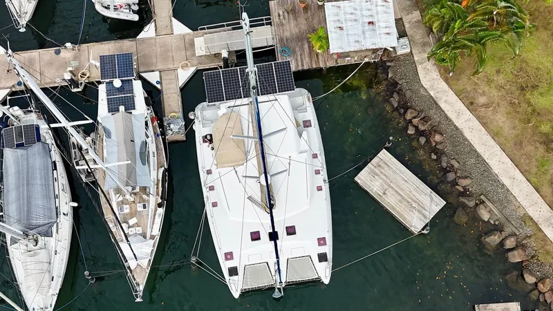 Road Less Travelled Yacht Photos Pics Aerial view of a 2013 Lagoon 421 catamaran docked at a marina with solar panels.