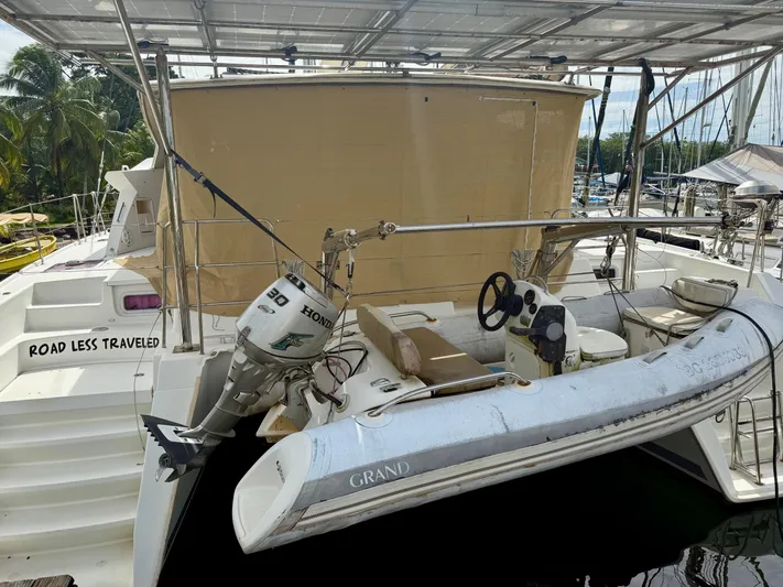 Road Less Travelled Yacht Photos Pics 2013 Lagoon 421 catamaran with dinghy and Honda outboard motor at marina.