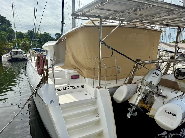 Road Less Travelled Yacht Photos Pics 2013 Lagoon 421 catamaran docked, featuring a covered deck and outboard motor.
