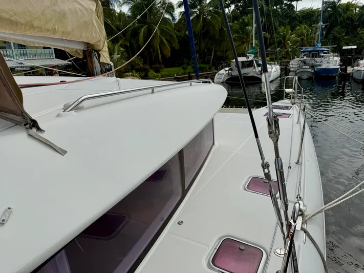 Road Less Travelled Yacht Photos Pics 2013 Lagoon 421 catamaran docked in a tropical marina with lush greenery.