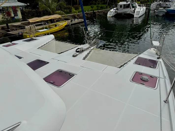 Road Less Travelled Yacht Photos Pics 2013 Lagoon 421 catamaran docked, featuring spacious deck and netting, with nearby boats and lush surroundings.