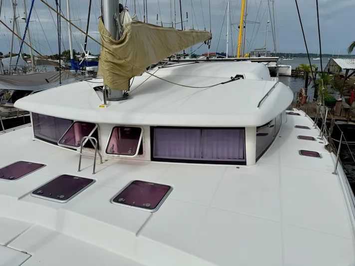 Road Less Travelled Yacht Photos Pics 2013 Lagoon 421 catamaran with covered sail, docked in a marina.