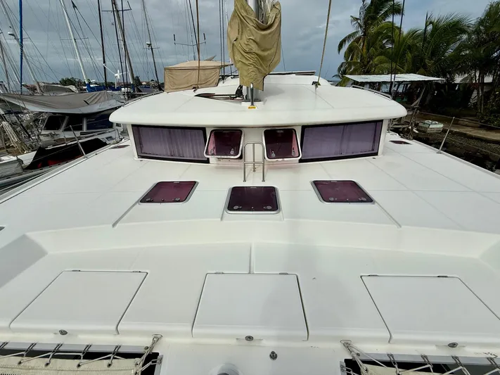 Road Less Travelled Yacht Photos Pics 2013 Lagoon 421 catamaran deck with hatches, docked near palm trees.