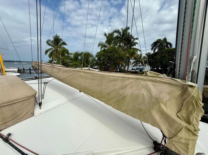 Road Less Travelled Yacht Photos Pics Sailboat deck of 2013 Lagoon 421 with covered boom, surrounded by palm trees and ocean.