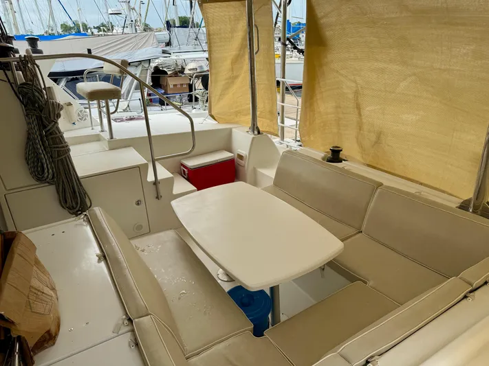 Road Less Travelled Yacht Photos Pics Interior of 2013 Lagoon 421 catamaran with seating area and table, docked at marina.
