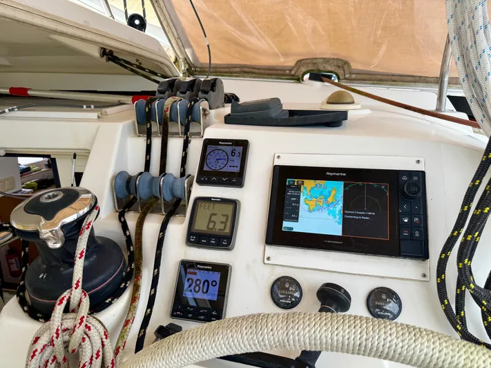 Road Less Travelled Yacht Photos Pics Control panel of a 2013 Lagoon 421 catamaran with navigation instruments and ropes.