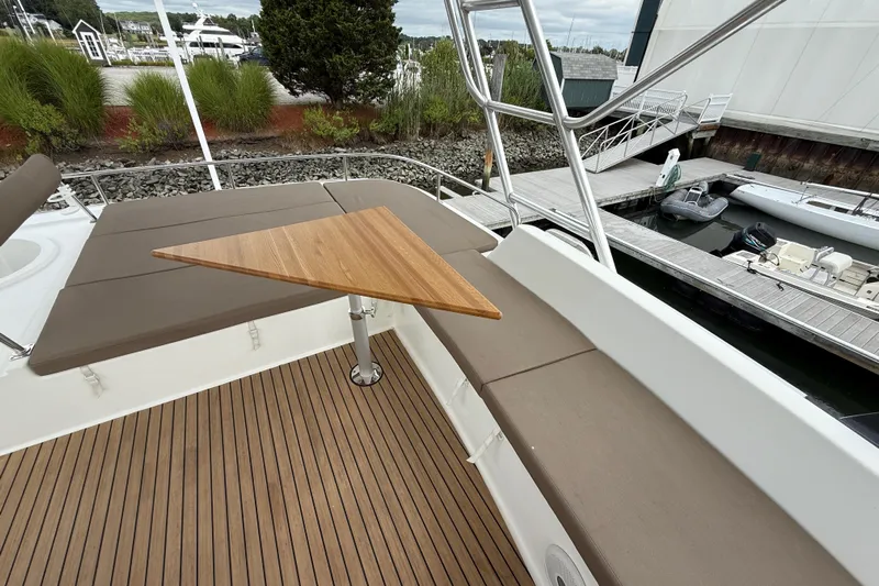 Ohana Yacht Photos Pics 2015 Fountaine Pajot Summerland 40 LC yacht with cushioned seating and wooden table on deck.