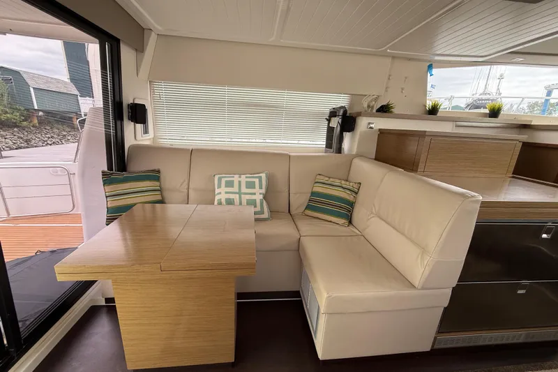 Ohana Yacht Photos Pics Interior of 2015 Fountaine Pajot Summerland 40 LC with cozy seating and wooden table.