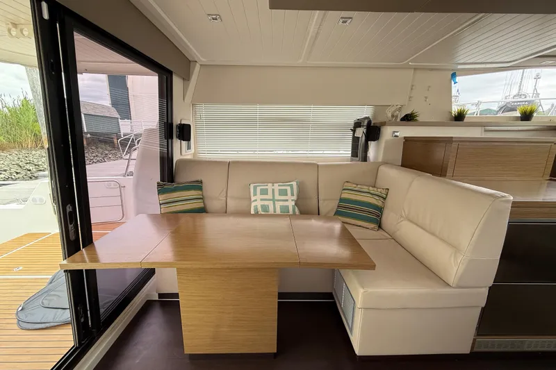 Ohana Yacht Photos Pics Interior of 2015 Fountaine Pajot Summerland 40 LC with cozy seating and wooden table.