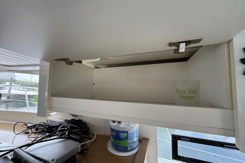 Ohana Yacht Photos Pics Open cabinet on 2015 Fountaine Pajot Summerland 40 LC yacht with "Sea Side Sipper" cup inside.