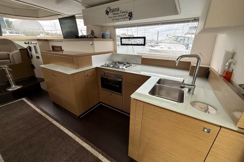 Ohana Yacht Photos Pics Modern kitchen interior of 2015 Fountaine Pajot Summerland 40 LC yacht with wood cabinetry.
