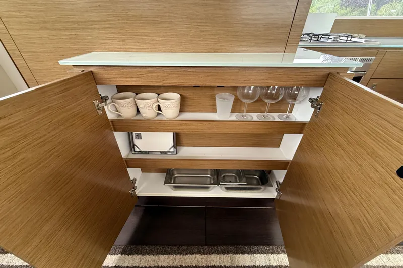 Ohana Yacht Photos Pics Open wooden cabinet in 2015 Fountaine Pajot Summerland 40 LC yacht kitchen.