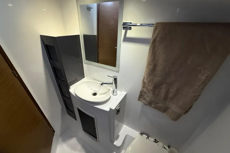 Ohana Yacht Photos Pics Compact bathroom in 2015 Fountaine Pajot Summerland 40 LC yacht with sink, mirror, and towel.