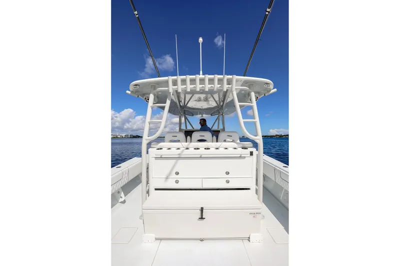  Yacht Photos Pics 2023 Contender 44 ST boat with center console, white seating, and blue sky background.