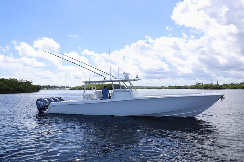  Yacht Photos Pics 2023 Contender 44 ST boat on calm water under a partly cloudy sky.