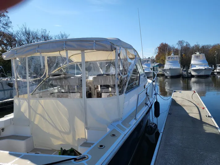  Yacht Photos Pics 2002 Mainship Pilot 34 docked at marina under clear blue sky.