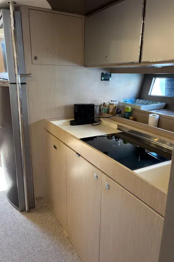 (2021 And 2024 Retrofit) Yacht Photos Pics Modern kitchen interior of 2003 Riva 52' LE yacht with sleek cabinetry and appliances.