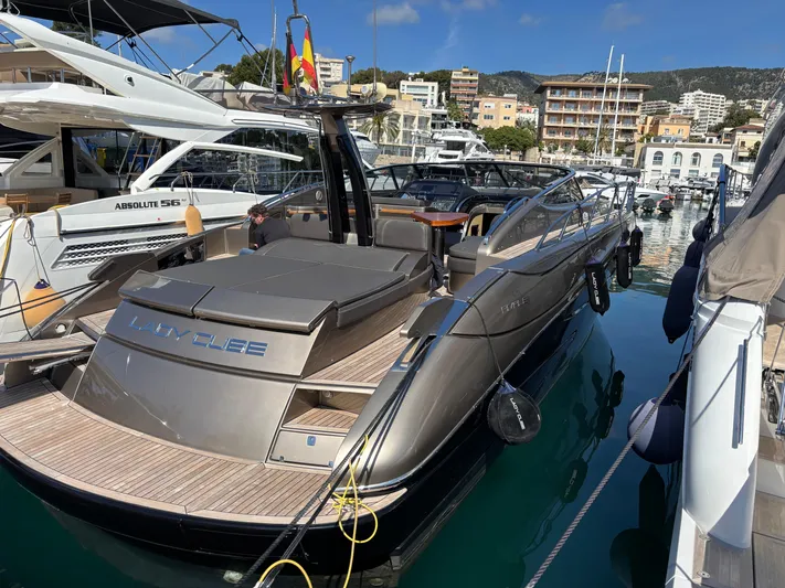 (2021 And 2024 Retrofit) Yacht Photos Pics Luxury 2003 Riva 52' le yacht docked in a marina, surrounded by other boats.