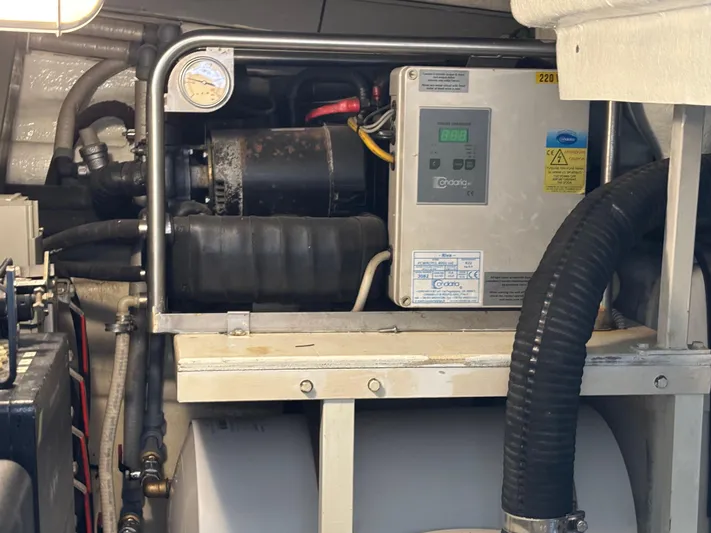 (2021 And 2024 Retrofit) Yacht Photos Pics Engine room of a 2003 Riva 52' LE yacht, showcasing mechanical components and control panel.