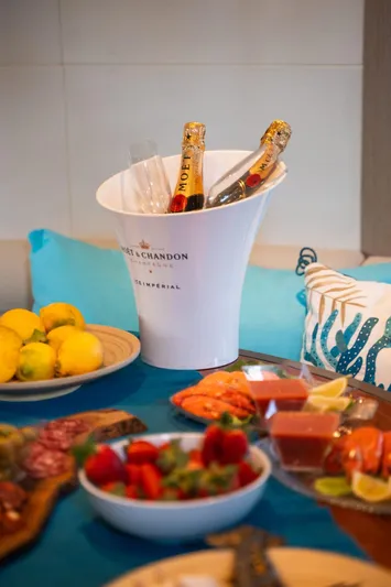 (2021 And 2024 Retrofit) Yacht Photos Pics Luxurious yacht dining setup with champagne, fruits, and appetizers on a Riva 52' le, 2003.