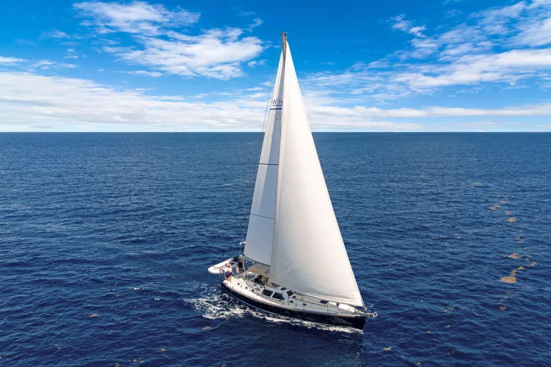 Mrs Jones Yacht Photos Pics Sailing yacht Hylas 54, 2009 model, cruising on open ocean under clear blue skies.