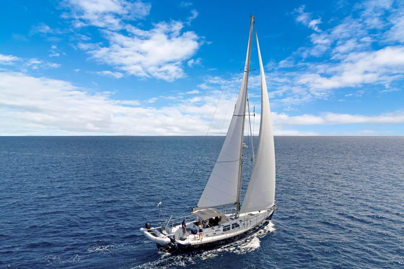 Mrs Jones Yacht Photos Pics Sailing yacht Hylas 54, 2009 model, cruising on open ocean under clear blue skies.