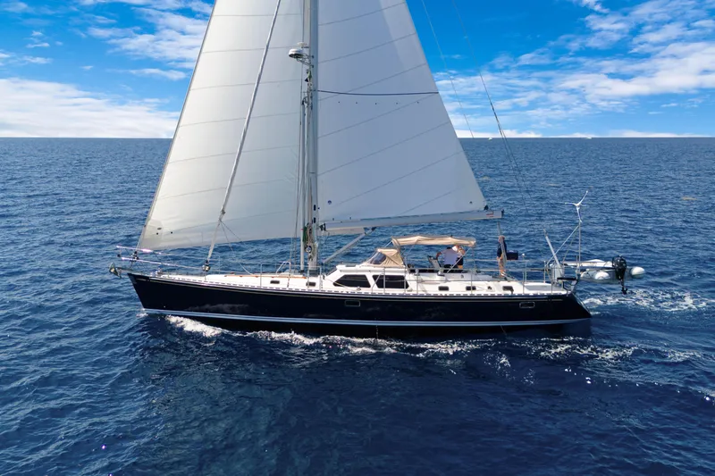 Mrs Jones Yacht Photos Pics Sailing yacht Hylas 54, 2009 model, cruising on open ocean under clear blue skies.